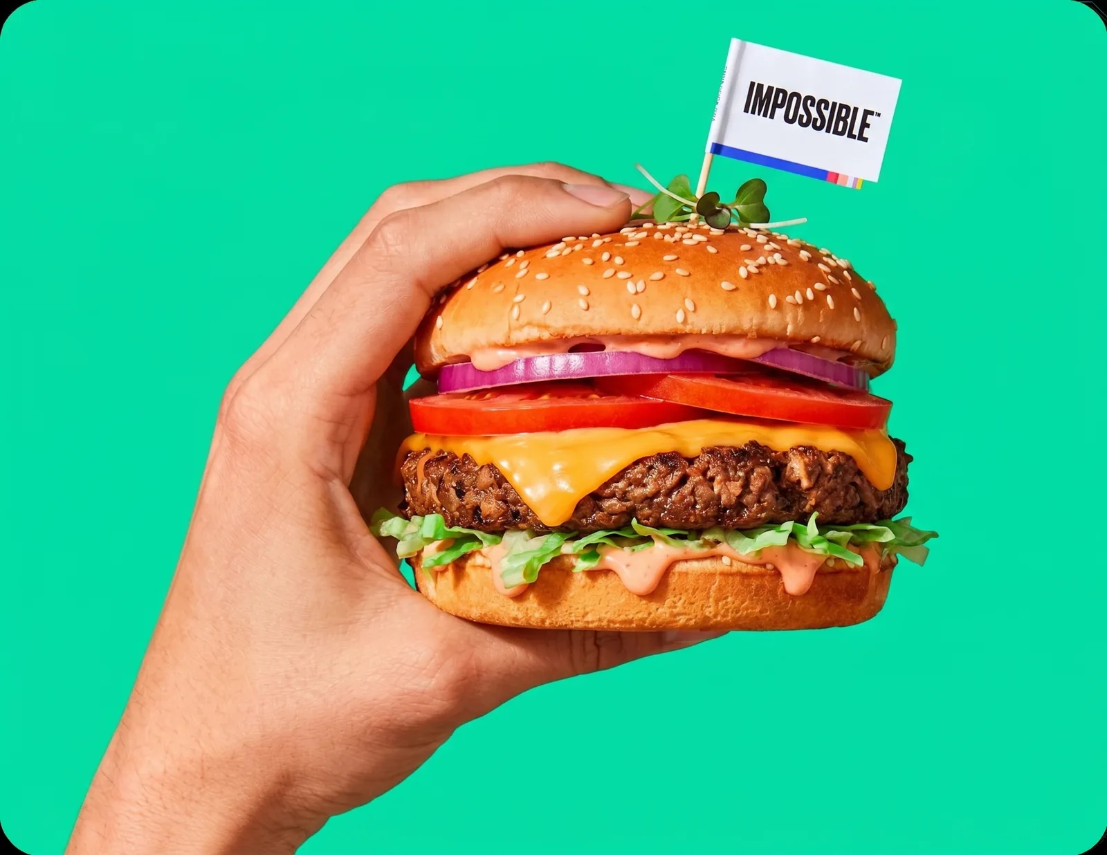 Impossible burger held in one hand