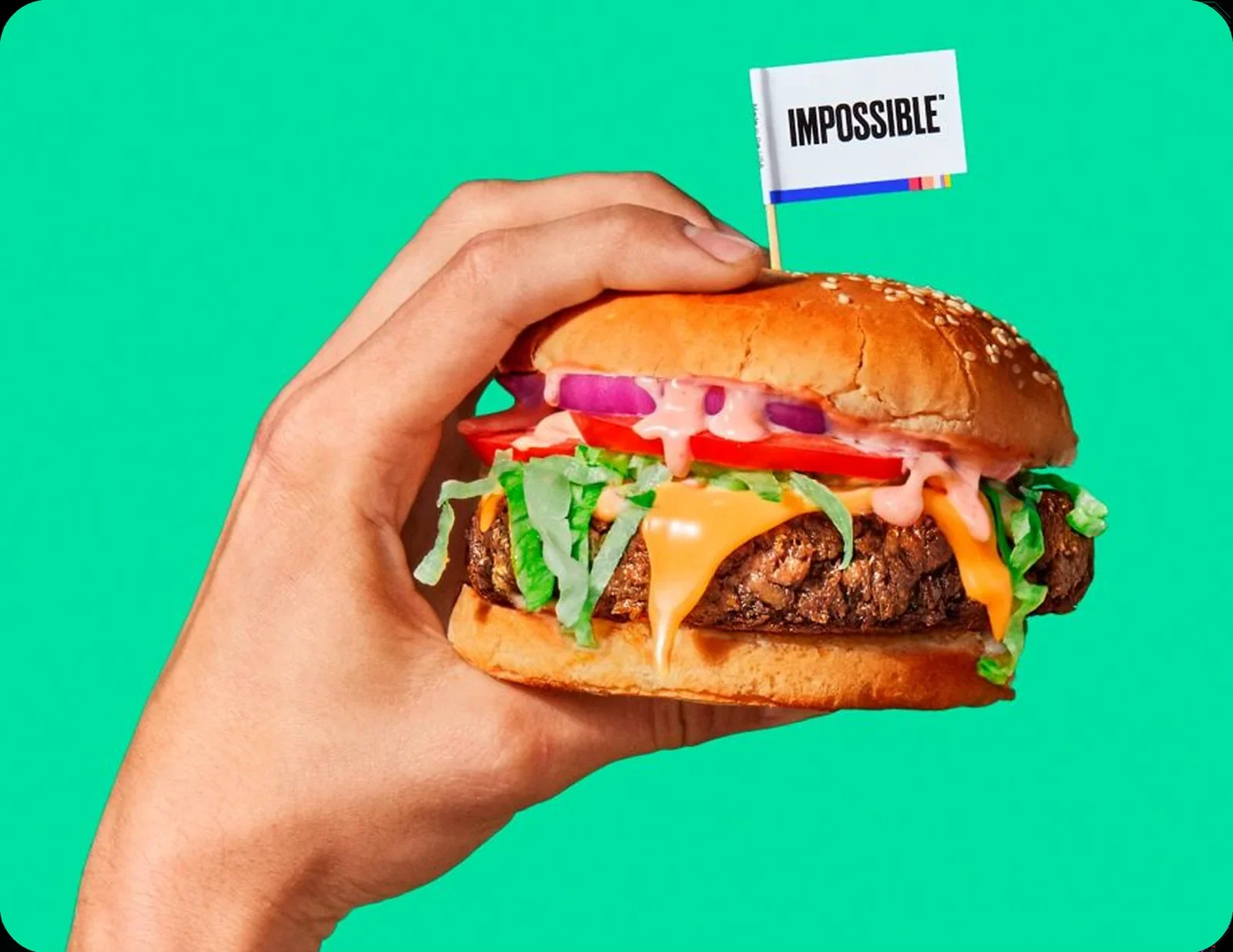 Impossible burger held in one hand